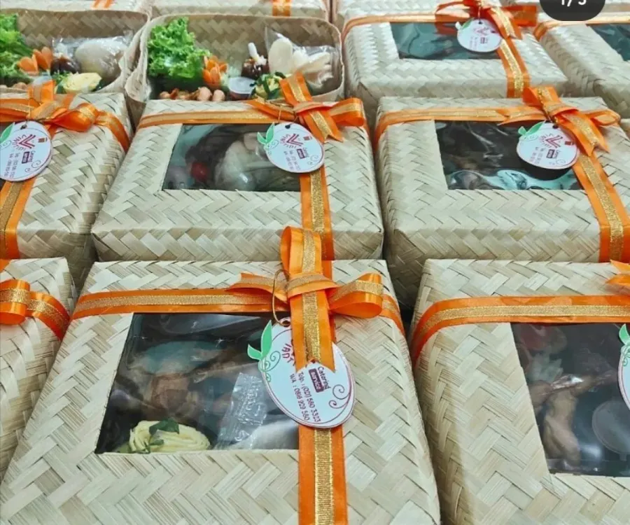 Paket nasi box dalam kemasan anyaman dengan pita jingga